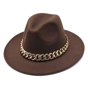 Detail of dark brown wool fedora featuring a prominent thick gold chain decoration