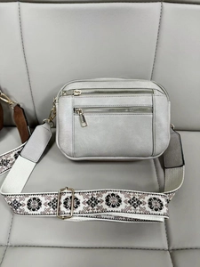 Detail of light grey multi-zipper crossbody bag with floral embroidered strap