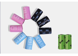 Rolls of colorful biodegradable dog waste bags with bone print in pink, blue and green