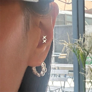Minimalist 925 silver star stud earrings and beaded hoop charm worn in a lifestyle setting