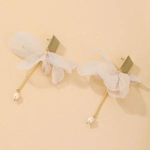 Detail of gold metal earrings with beige tulle bow, long rod and pearl drop pendant