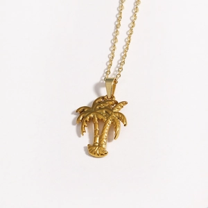 Macro detail of golden coconut tree pendant necklace with high-quality metallic texture