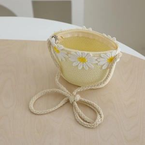 Detail of girls straw bag featuring white daisy embroidery and zipper closure
