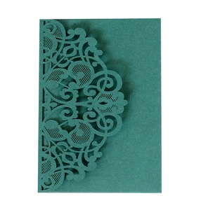 Macro view of detailed laser-cut lace pattern on green wedding invitation envelope