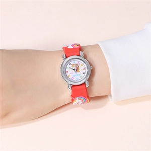 Détail du bracelet en silicone rouge avec relief licorne et boîtier métallique poli