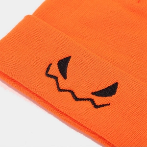 Orange Halloween knit beanie featuring black embroidered pumpkin devil face expression
