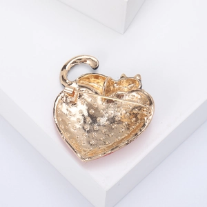 Detailed back view of a golden heart cat brooch showing secure pin and textured finish