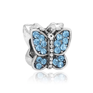 Macro shot of silver butterfly charm with blue rhinestones and reflective base