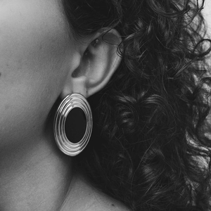 Close-up of double-layered silver textured hoop earrings worn on female model