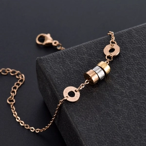 Three-tone titanium steel bracelet with rose gold cylinders on black jewelry box