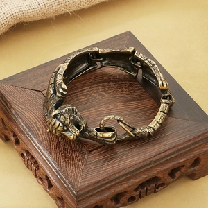 Detailed view of vintage gold tiger head bracelet on an ornate wooden display stand