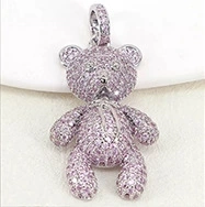 Detail of silver teddy bear pendant featuring pink crystal rhinestones and metal loop