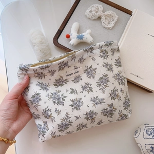 Detailed view of floral cotton makeup bag with purple flower patterns and simple wish label