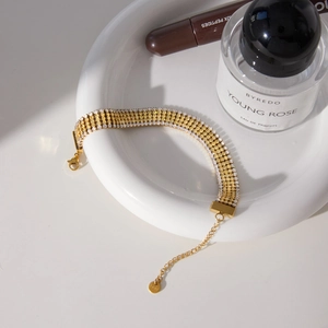 Dettaglio del bracciale tennis placcato oro a più file con cristalli gialli e chiusura