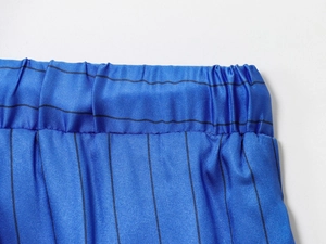Detail view of the elastic waistband on blue striped trousers with precise stitching