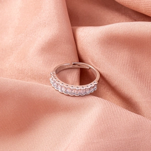 Detail of adjustable silver ring featuring sparkling rectangular zircon stones and silk backdrop