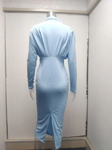 Detail view of the back slit and slim waist of the long sleeve light blue maxi dress