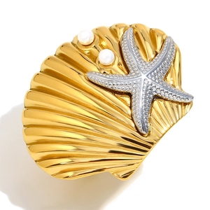 Golden scallop and silver starfish brooch with pearls on a clean white background