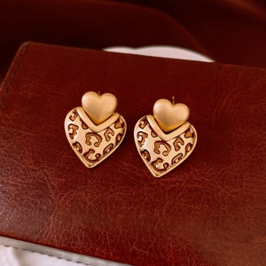 Macro shot of vintage heart leopard print earrings with gold metal base on leather