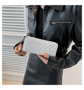 Gros plan sur le portefeuille blanc en cuir matelassé avec surpiqûres en V