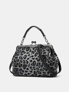 Detailed view of retro leopard print handbag with metallic clasp and leather strap