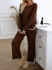 Detail of brown knitted set with white contrast stripes on cuffs and wide leg pants