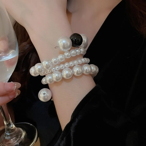 Macro detail of multilayer pearl wrap bracelet with white and black pearls