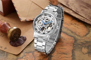 Détail d'une montre automatique squelette argentée avec aiguilles bleues sur carte