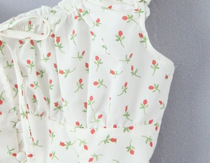 Close-up of floral print top featuring ruffle neckline and round button details