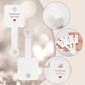 Detail of white jewelry display card with Handmade with Love text and hanging hook