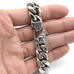 Close-up of silver stainless steel Cuban link bracelet with unique vine clasp detail