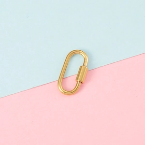 Detailed view of a gold oval stainless steel screw clasp on a soft pastel background