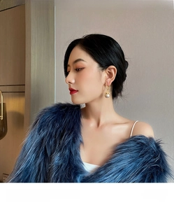 Elegant pearl earrings featuring gold hoops and zircon accents worn by a model
