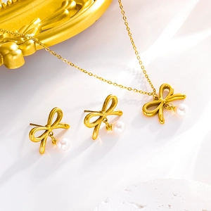 Gros plan détaillé d'un ensemble de bijoux nœud papillon et perles dorées avec collier