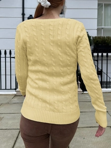 Detail view of the yellow cable-knit sweater back with high-quality texture and outdoor style