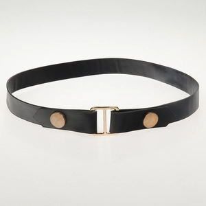 Close-up of black faux leather belt with golden H buckle and circular metal rivets