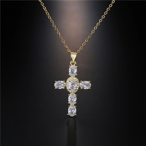 Elegant gold cross necklace with oval-shaped cubic zirconia and halo diamond detailing