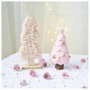 Detail of handmade knit and pink felt Christmas tree ornaments with pearls and bells