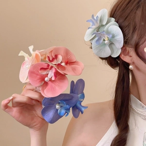 Detail of orchid hair clip with gradient fabric petals and a central white pearl