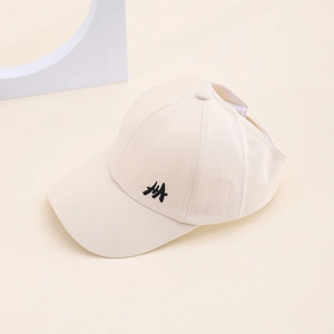 Détail de la casquette beige en sergé de coton avec logo brodé noir et texture fine