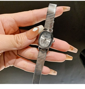 Detail shot of a silver vintage oval quartz watch with an elastic metal expansion band