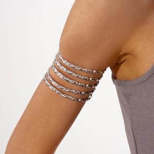 Detail of silver multilayer spiral arm cuff featuring textured hammered metal finish