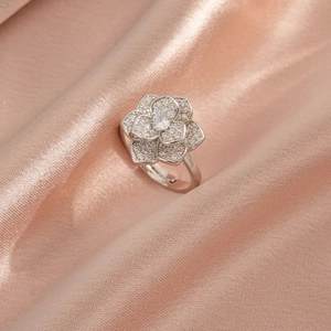 Détail d'une bague fleur en argent avec pavé de zircons sur un tissu en satin rose