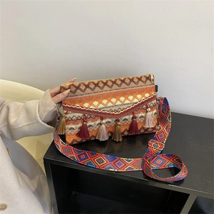 Detail of woven crossbody bag with colorful tassels and ethnic geometric shoulder strap