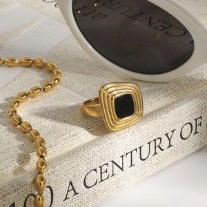 Close-up of a gold-plated titanium steel ring with a square black agate-style inlay