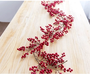 Close-up of artificial red berry vine with glossy finish on natural wooden background