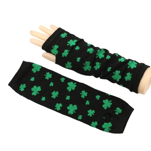 Detailed knit of long black fingerless gloves featuring green clover patterns and thumb holes