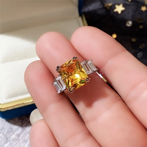 Macro detail of luxury ring with yellow square-cut gemstone and side baguettes on a box
