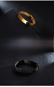 Detailed macro view of gold and black mesh band stainless steel bracelets on leather