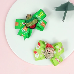 Détail de barrettes de Noël avec Père Noël scintillant et sapin sur rubans